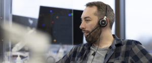 Image of man with headphones on in front of computer